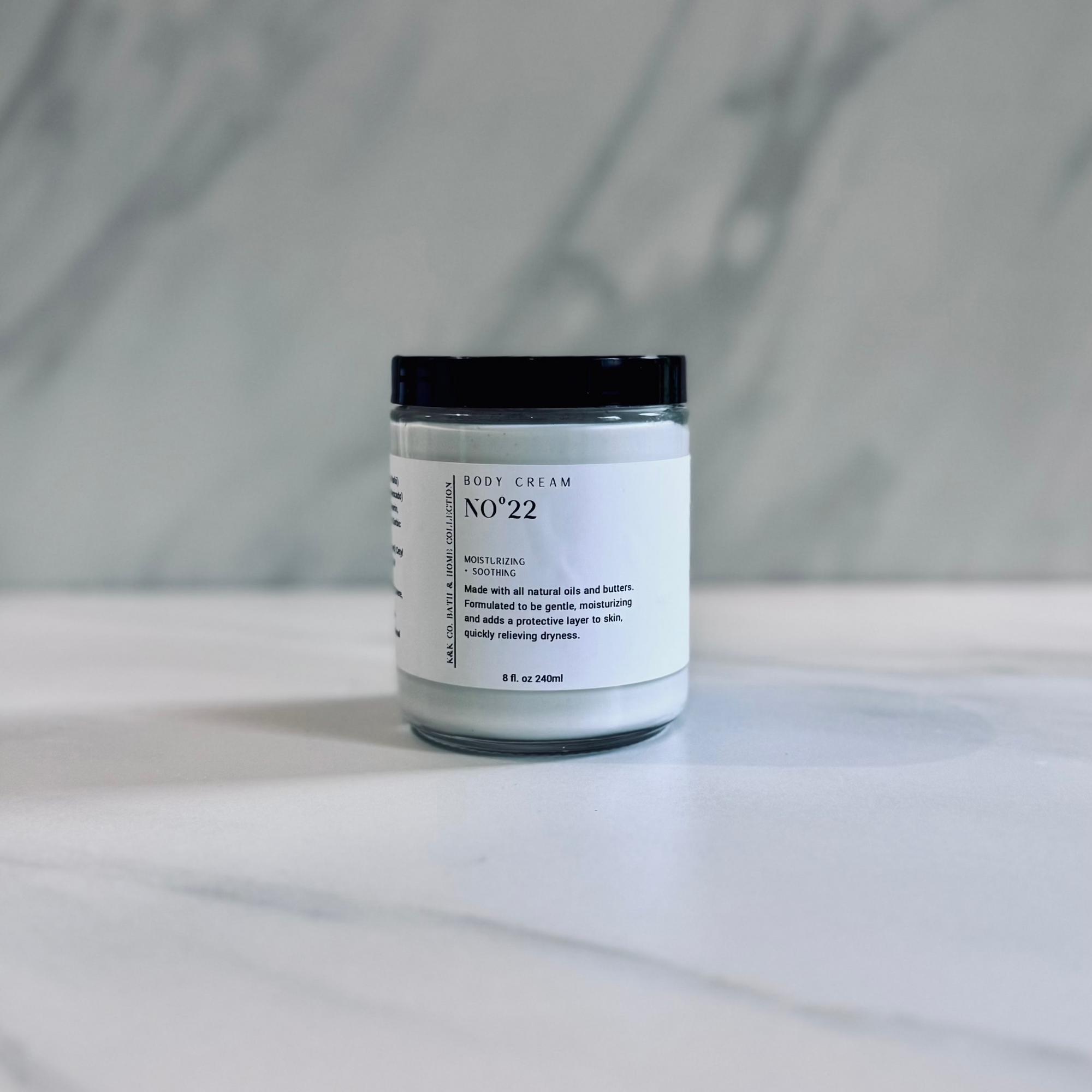 A jar of No. 22 Body Cream on a marble surface.